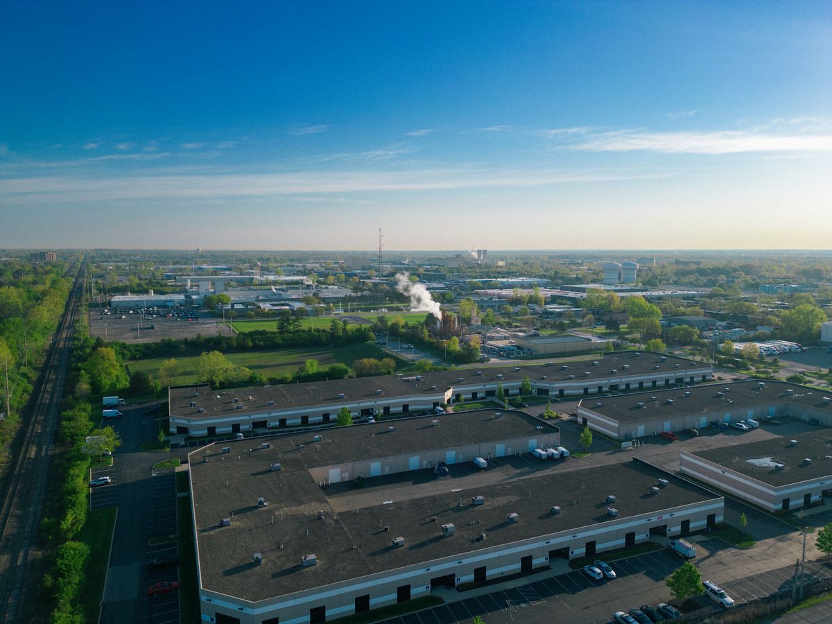 Aerial view of a data center campus with large roof and pavement